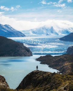 Persona observando inmenso glaciar y montañas