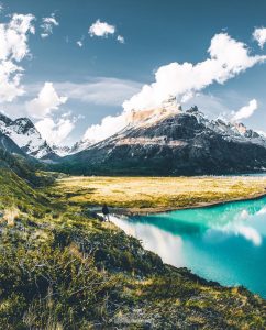 Lago color turquesa bajo grandes montañas